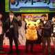 Pokken’s producer holding a giant stuffed Pikachu beside the Tokaigi tournament winners.